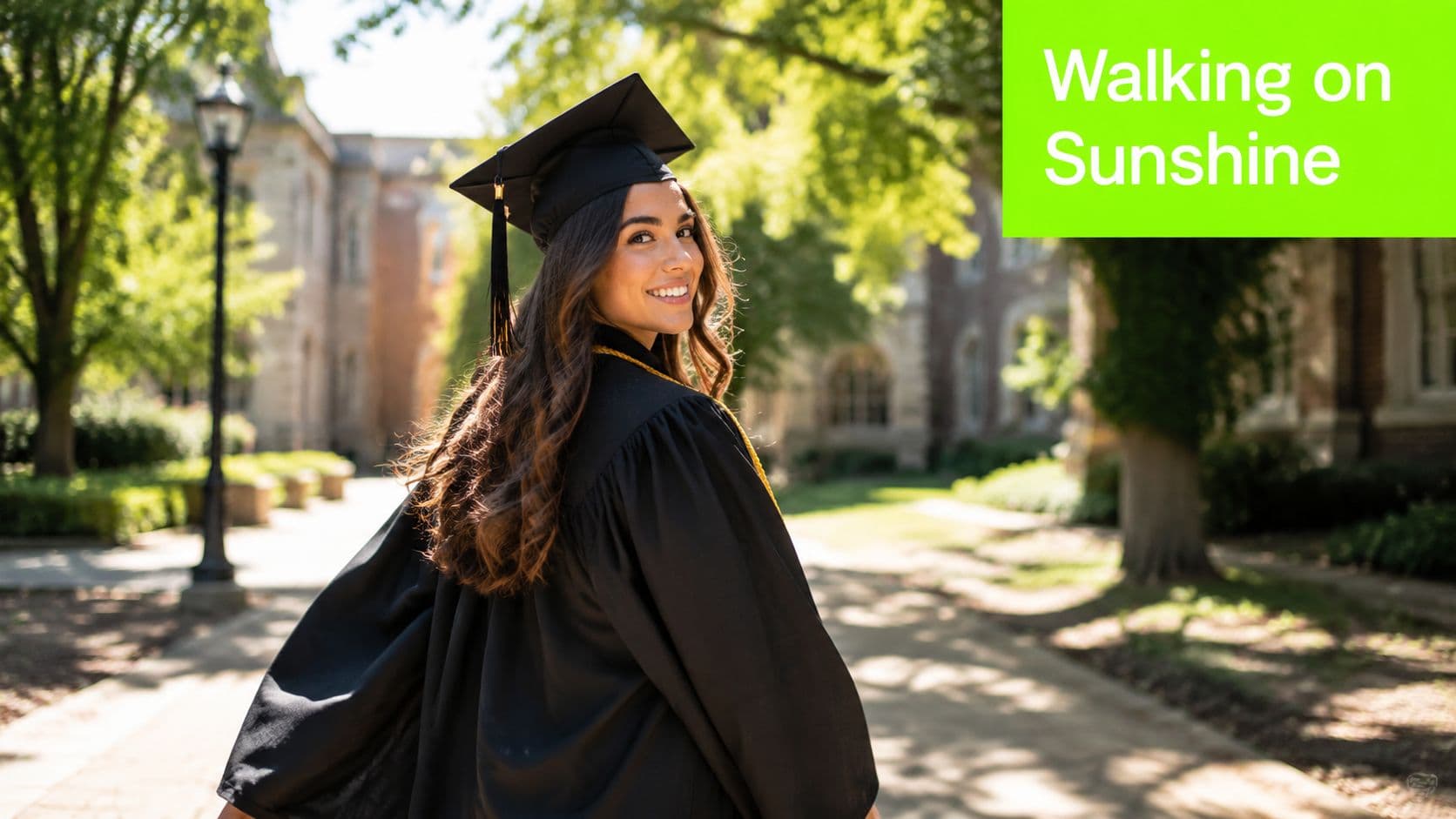 A happy female college graduate in her cap and gown smiles while walking outdoors on campus.